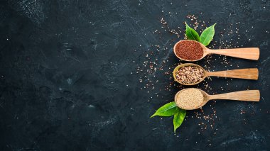 Kırmızı, beyaz ve kahverengi kinoa seti. Siyah bir arka planda. Üst Manzara. Boş kopyalama alanı.