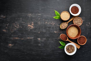 Kırmızı, beyaz ve kahverengi kinoa seti. Siyah bir arka planda. Üst Manzara. Boş kopyalama alanı.