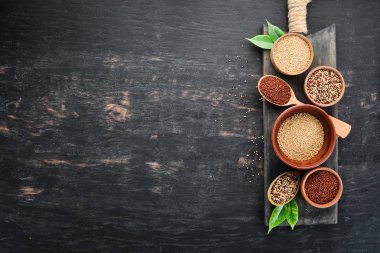 Kırmızı, beyaz ve kahverengi kinoa seti. Siyah bir arka planda. Üst Manzara. Boş kopyalama alanı.