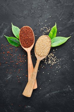 Kırmızı, beyaz ve kahverengi kinoa seti. Siyah bir arka planda. Üst Manzara. Boş kopyalama alanı.