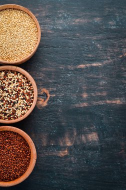 Kırmızı, beyaz ve kahverengi kinoa seti. Siyah bir arka planda. Üst Manzara. Boş kopyalama alanı.