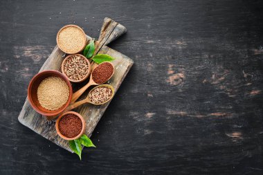 Kırmızı, beyaz ve kahverengi kinoa seti. Siyah bir arka planda. Üst Manzara. Boş kopyalama alanı.