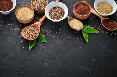 Kırmızı, beyaz ve kahverengi kinoa seti. Siyah bir arka planda. Üst Manzara. Boş kopyalama alanı.