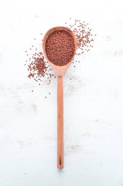 Kırmızı Quinoa. Beyaz ahşap bir arka plan üzerinde. Üst te. Ücretsiz kopyalama alanı.