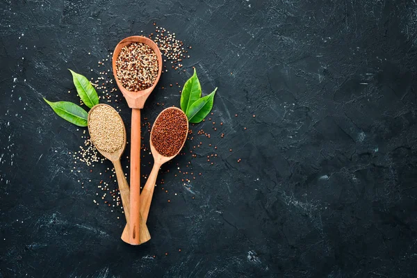 Kırmızı, beyaz ve kahverengi kinoa seti. Siyah bir arka planda. Üst Manzara. Boş kopyalama alanı.