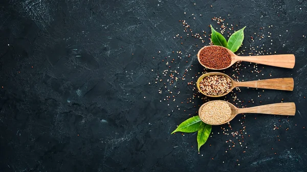 Kırmızı, beyaz ve kahverengi kinoa seti. Siyah bir arka planda. Üst Manzara. Boş kopyalama alanı.