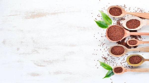 Kırmızı Quinoa. Beyaz ahşap bir arka plan üzerinde. Üst te. Ücretsiz kopyalama alanı.