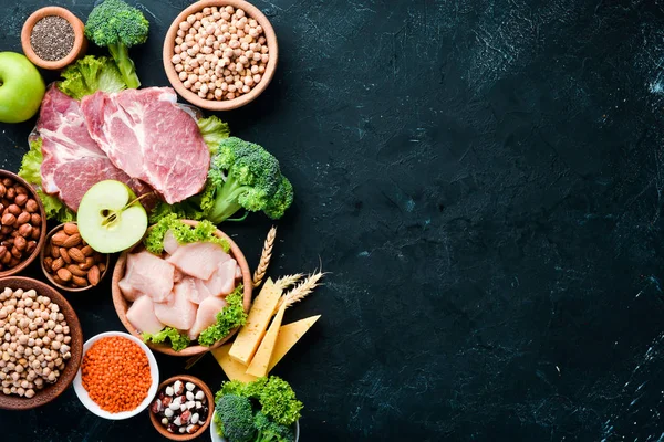 Sağlıklı protein kaynağı ve vücut geliştirme gıdaların çeşitleri. Et, tavuk filetosu, brokoli, fasulye, peynir, yumurta, buğday. Taş arka planda.