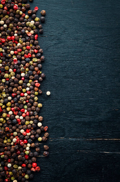 Red and black pepper on a wooden background. Spices Top view. Free space for your text.