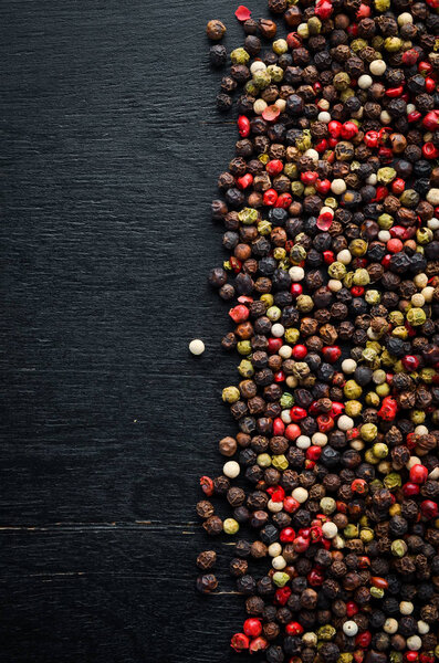 Red and black pepper on a wooden background. Spices Top view. Free space for your text.