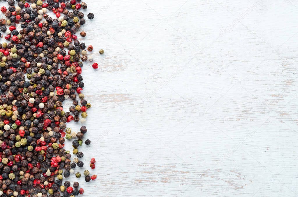 Red and black pepper on a wooden background. Spices Top view. Free space for your text.