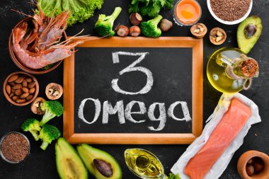Doğal Omega 3 vitamini ile gıda. Sağlıklı gıda: balık, karides, brokoli, keten, fındık, yumurta, maydanoz. Üst te. Metniniz için boş alan. Siyah arka planda.