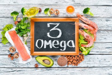 Omega 3 içeren gıdalar. Vitamin Sağlıklı gıdalar: avokado, balık, karides, brokoli, keten, fındık, yumurta, maydanoz. Üst te. Metniniz için boş alan. Beyaz ahşap arka planda.