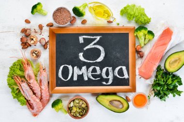 Omega 3 içeren gıdalar. Vitamin Sağlıklı gıdalar: avokado, balık, karides, brokoli, keten, fındık, yumurta, maydanoz. Üst te. Metniniz için boş alan. Beyaz ahşap arka planda.