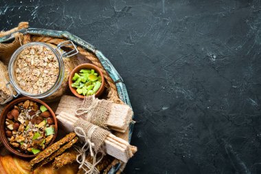 Tahta bir kutuda sağlıklı atıştırmalıklar. yulaf ezmesi barlar, kruvasan, kuru üzüm, fındık. Üst te. Metniniz için boş alan.