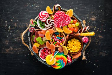 Ahşap bir kutuda renkli şekerler, jöle ve marmelat. Tatlı. Eski arka planda. Üst te. ücretsiz kopyalama alanı.