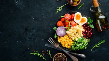 Mısırlı makarna, yumurta, domates, arugula, bir kapta. Bowl Buddha Top görünümü. metniniz için boş alan.