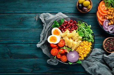 Mısırlı makarna, yumurta, domates, arugula, bir kapta. Bowl Buddha Top görünümü. metniniz için boş alan.