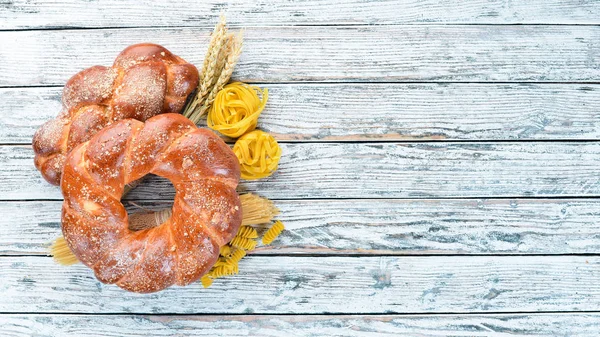 Glütensiz yiyecekler. Beyaz ahşap arka planda çeşitli makarna, ekmek, atıştırmalıklar ve un. Üst te. Metniniz için boş alan.