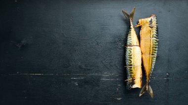 Füme balık Siyah ahşap bir arka plan üzerinde. Üst te. Metniniz için boş alan.