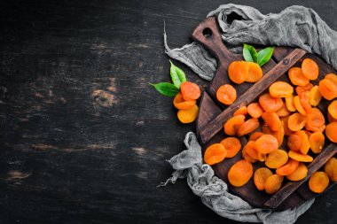 Siyah bir arka plan üzerinde kuru kayısı. Kurutulmuş meyve Üst görünüm. Metniniz için boş alan.