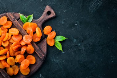 Siyah bir arka plan üzerinde kuru kayısı. Kurutulmuş meyve Üst görünüm. Metniniz için boş alan.