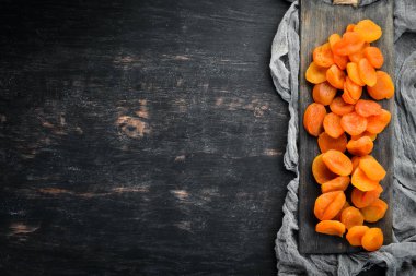 Siyah bir arka plan üzerinde kuru kayısı. Kurutulmuş meyve Üst görünüm. Metniniz için boş alan.