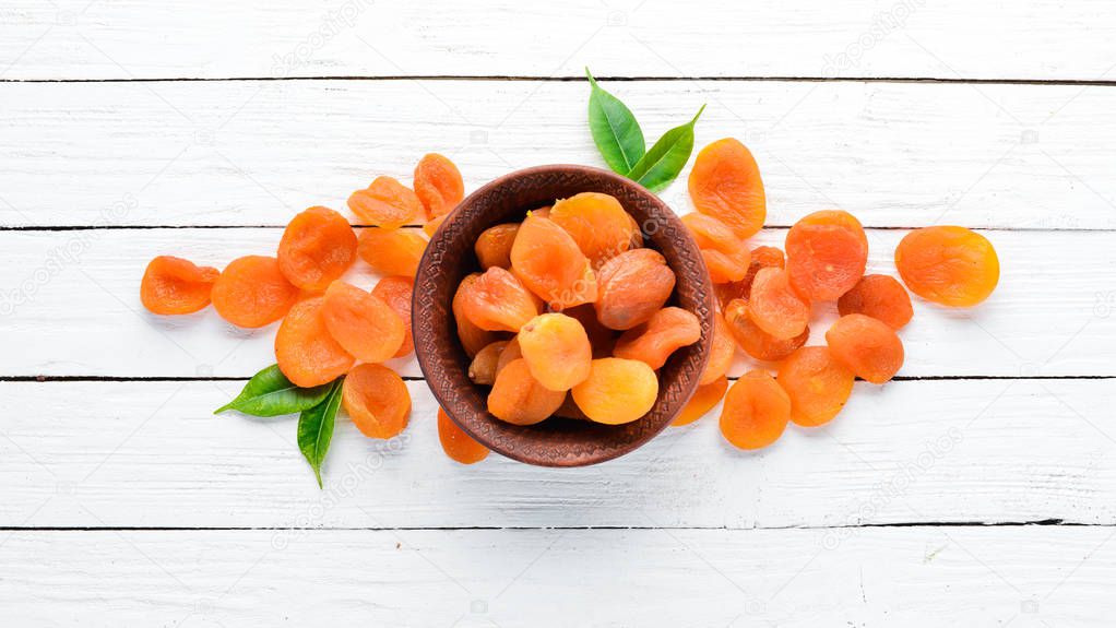 Dried apricots on a white wooden background. Dried fruit Top view. Free space for your text.