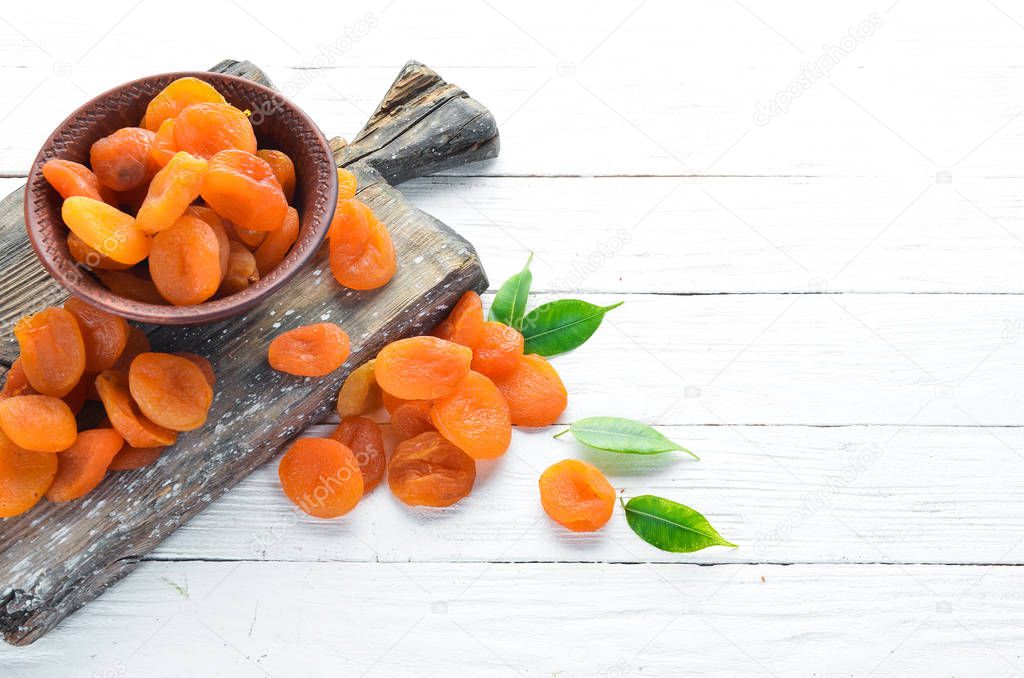 Dried apricots on a white wooden background. Dried fruit Top view. Free space for your text.