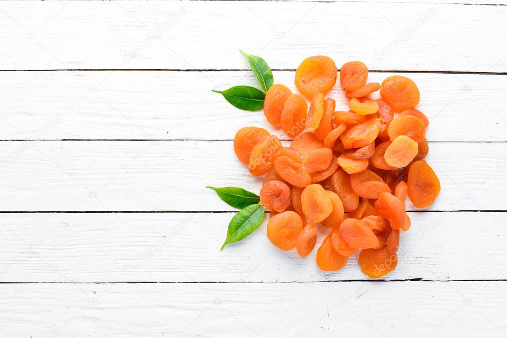 Dried apricots on a white wooden background. Dried fruit Top view. Free space for your text.