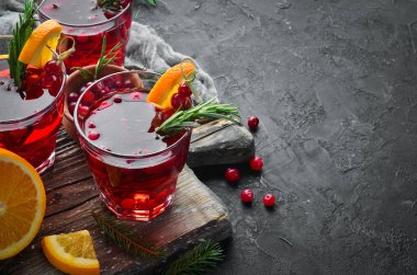 Kızılcık suyu olan bardaklar. Kızılcık, limon, biberiye. Rustik bir arka planda. Üst te. Metniniz için boş alan.