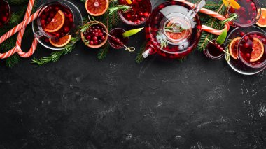 Kokteyller ve kızılcıklı içecekler. Kızılcık, limon, biberiye. Siyah bir arka plan üzerinde. Üst te. Metniniz için boş alan.