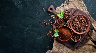 Öğütülmüş kahve ve kahve çekirdekleri. Siyah bir arka plan üzerinde kahve çeşitleri nin çeşitleri. Üst te. Metniniz için boş alan.