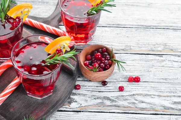 Glasses with cranberry juice. Cranberries, limes, rosemary. On a rustic background. Top view. Free space for your text.