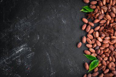 Siyah bir arka plan üzerinde kakao çekirdekleri. Üst te. Ücretsiz kopyalama alanı.