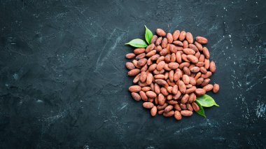 Siyah bir arka plan üzerinde kakao çekirdekleri. Üst te. Ücretsiz kopyalama alanı.