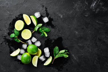 Siyah taş zemin üzerinde kireç, buz ve nane. Üst te. Metniniz için boş alan.