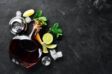 Alkollü İçecek Rom, siyah taş arka plan üzerinde kireç ve nane. Üst te. Metniniz için boş alan.