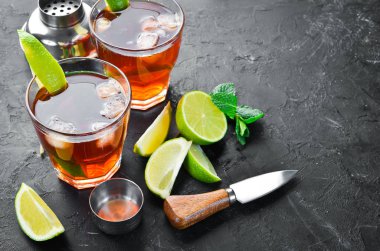 Alkollü İçecek Rom, siyah taş arka plan üzerinde kireç ve nane. Üst te. Metniniz için boş alan.