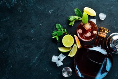 Alkollü İçecek Rom, siyah taş arka plan üzerinde kireç ve nane. Üst te. Metniniz için boş alan.