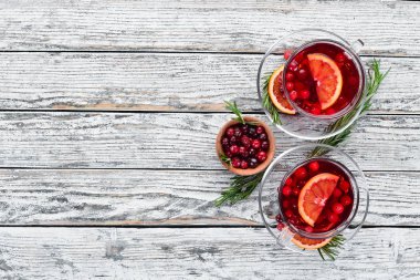 Sıcak kızılcık ve portakal içeceği, bardaklarda. Beyaz ahşap bir arka plan üzerinde. Üst te. Metniniz için boş alan.