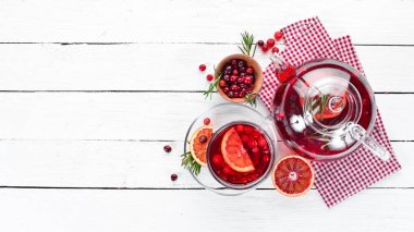 Sıcak kızılcık ve portakal içeceği, bardaklarda. Beyaz ahşap bir arka plan üzerinde. Üst te. Metniniz için boş alan.