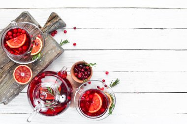 Sıcak kızılcık ve portakal içeceği, bardaklarda. Beyaz ahşap bir arka plan üzerinde. Üst te. Metniniz için boş alan.