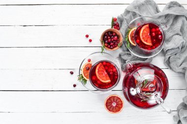 Sıcak kızılcık ve portakal içeceği, bardaklarda. Beyaz ahşap bir arka plan üzerinde. Üst te. Metniniz için boş alan.