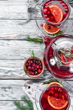 Sıcak kızılcık ve portakal içeceği, bardaklarda. Beyaz ahşap bir arka plan üzerinde. Üst te. Metniniz için boş alan.