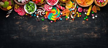 Renkli şekerler ve lolipop arka plan. Tatlı. Siyah bir arka plan üzerinde. Üst te. ücretsiz kopyalama alanı.