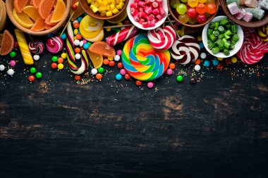 Renkli şekerler ve lolipop arka plan. Tatlı. Siyah bir arka plan üzerinde. Üst te. ücretsiz kopyalama alanı.