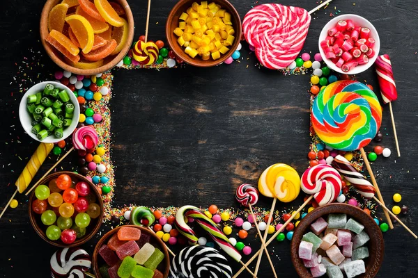 Hintergrund Aus Farbigen Bonbons Und Lutschern Süßigkeiten Auf Schwarzem Hintergrund — Stockfoto