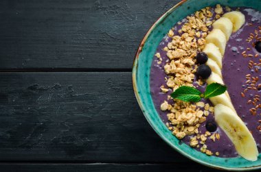 Bir kasede granola, yoğurt, yaban mersini ve muztaze kahvaltı. Üst te. Metniniz için boş alan.