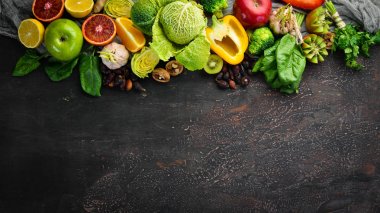 C vitamini içeren gıdalar: Portakal, limon, elma, gül, sarımsak, brokoli, elma, kivi, ıspanak. Üst te. Kahverengi arka planda.